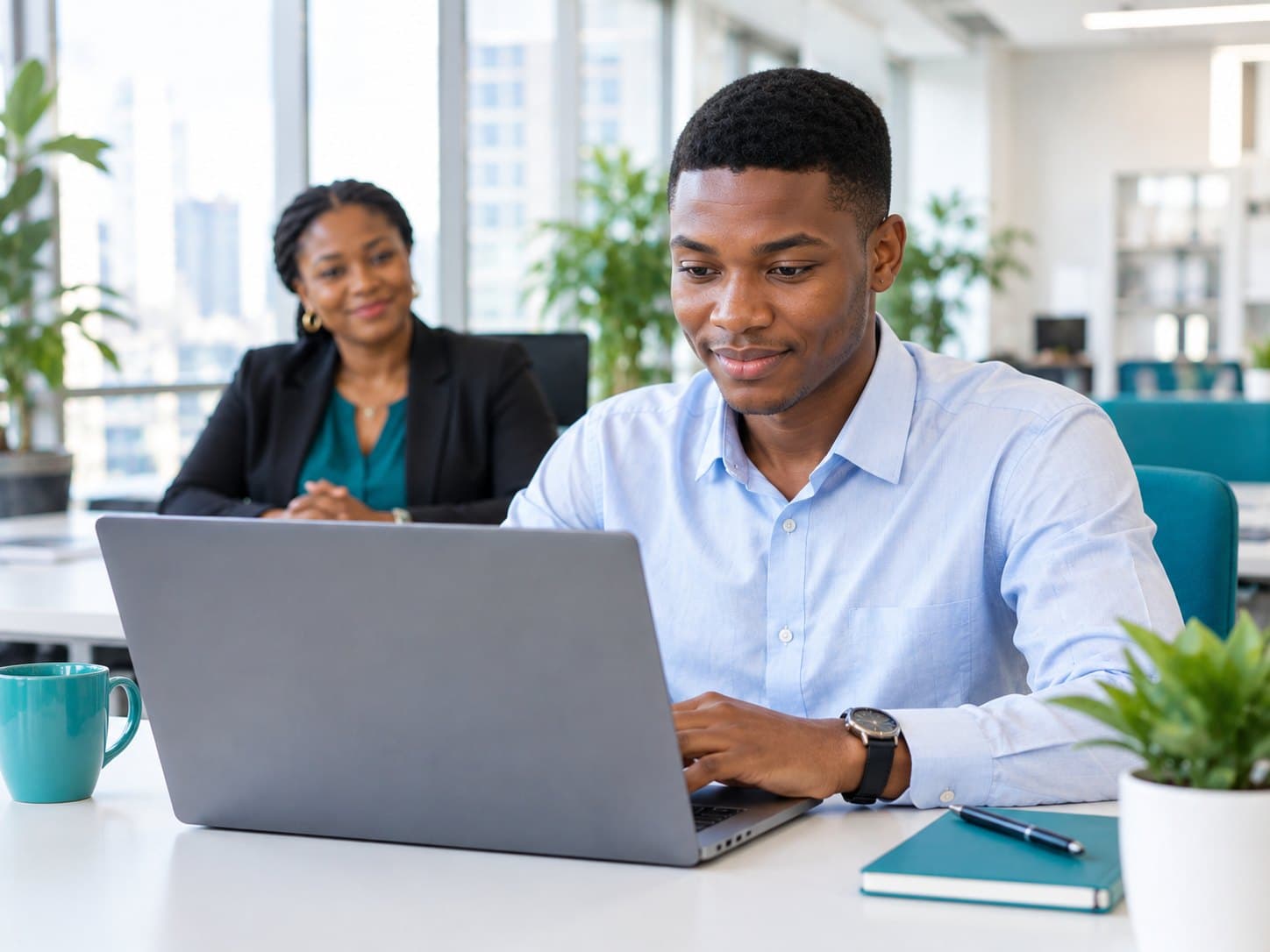 A graduate taking an online assessment on a laptop in an office